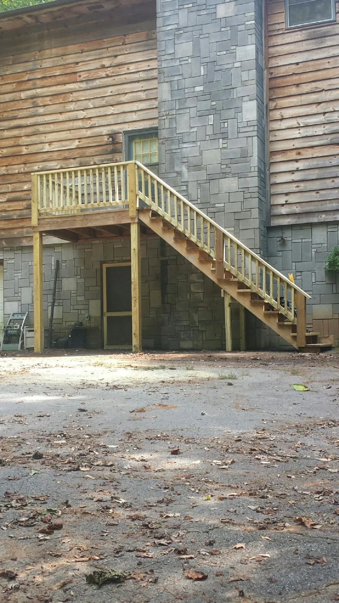 New pressure treated deck and stair landing on a log home in Linden